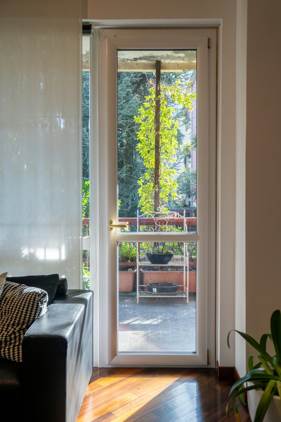 Moderný obytný priestor s výhľadom na slnečný balkón s rastlinami.